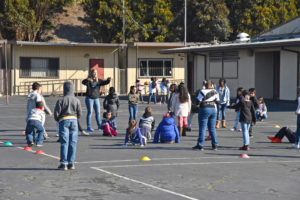 Adult at recess reminds students of boundaries during tag game
