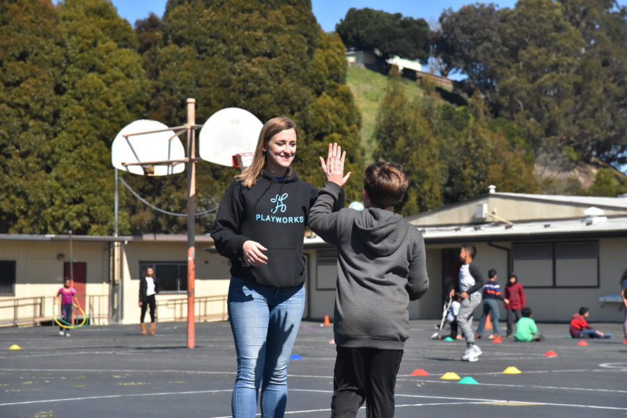 image of Playworks coach giving student high five